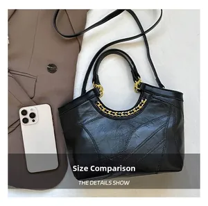 Dettaglio borsa shopper nera trapuntata con catena oro e telefono per confronto