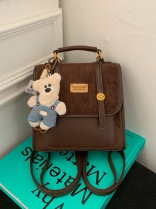 Deep brown stylish backpack for women featuring leather patchwork and a cute bear charm