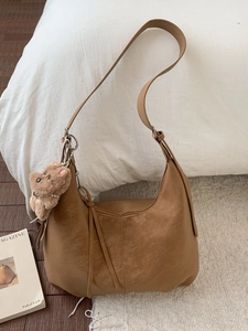 Sac hobo marron en simili cuir avec breloque ours en peluche sur fond blanc doux