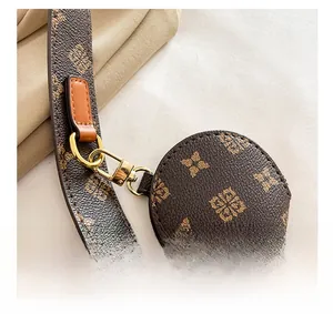 Detail of vintage monogram leather shoulder strap and round coin purse with gold hardware