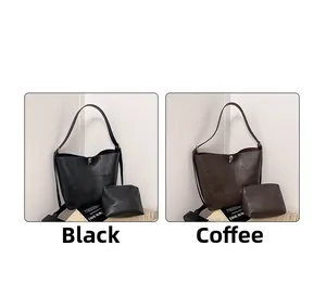 Comparison of black and brown tote bags with matching wristlets in minimalist home setting