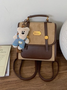 Retro leather backpack in brown and beige with a cute teddy bear charm and gold hardware