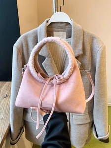 Pink frosted tote bag with plush trim and drawstring detail shown held against a suit