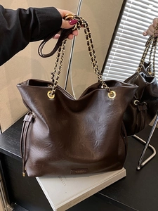 Dark brown faux leather tote bag with gold chain strap and drawstring side details