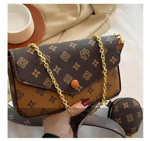 Detail shot of vintage patterned baguette bag with gold chain and round coin purse attachment