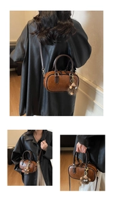Detailansicht der braunen Retro-Handtasche mit Plüschanhänger und verstellbarem Riemen
