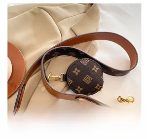 Detail of wide shoulder strap and mini round coin purse on vintage monogram baguette bag