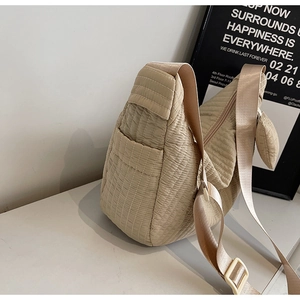Macro shot of beige quilted stripe texture with adjustable wide canvas strap and heart charm