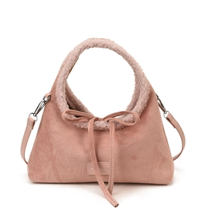Pink vintage suede handbag with faux shearling trim and decorative bow detail