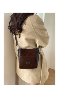 Detail of crossbody bag featuring retro brown suede and smooth leather patchwork texture