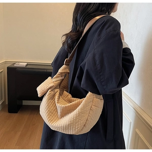 Detail showing khaki corduroy hobo bag texture and wide brown leather shoulder strap