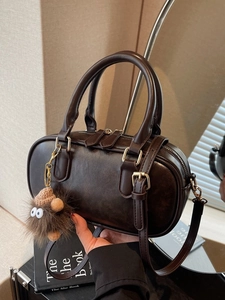 Retro brown Boston bag in matte leather with a cute monster plush charm on handles