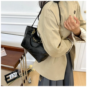 Dettaglio borsa tote nera in similpelle con cuciture geometriche e catena dorata