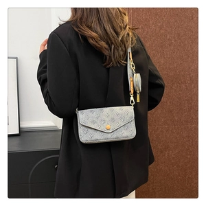 Rear view of a model wearing a canvas baguette crossbody bag with a round coin purse
