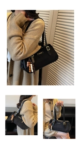 Close-up of black matte baguette bag with ZHCNMA logo and decorative beaded pendant