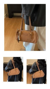 Detail of vintage brown baguette bag with matte texture and decorative beaded charm