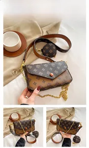 Detail of retro vintage crossbody bag with floral monogram print and gold chain strap