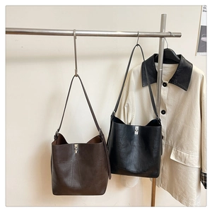 Detailed view of vintage large capacity bucket bags in brown and black leather with metal buckles