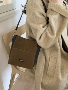 Retro brown suede and leather bucket bag with NO FILTER badge shown on a model