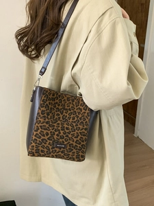 Leopard print bucket bag with brown leather trim and NO FILTER label shown on a shoulder
