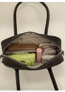 Vue intérieure montrant la grande capacité et les poches du sac cabas en daim marron