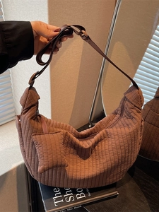 Brown quilted crescent hobo bag with matching mini pouch and vertical stitching texture