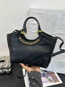Secchiello nero alla moda in ecopelle con cuciture geometriche e catena dorata