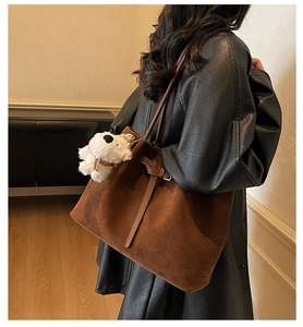 Dettaglio della grande borsa tote in pelle scamosciata marrone con ciondolo a cane