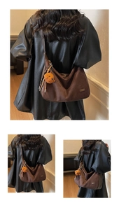 Détail du sac Hobo en daim marron foncé avec breloque ours et plaque logo en métal