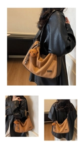 Détail d'un sac hobo en daim marron avec logo en métal, charm d'ours et franges en cuir