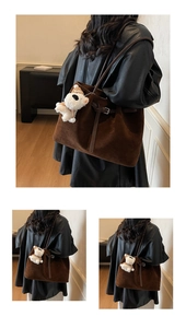Dettaglio di una borsa tote marrone opaca con spalline sottili e ciondolo a cucciolo