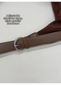 Detail of dark brown tote with adjustable shoulder strap and silver metal buckle