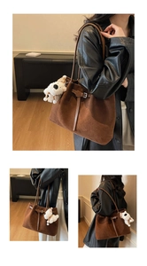 Dettaglio della borsa tote in pelle scamosciata marrone con cinturini in pelle