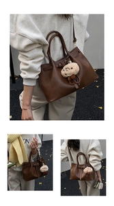Brown faux leather bucket bag with cute plush charm and adjustable shoulder strap