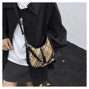 Detail of woven crescent shoulder bag featuring black leather trim and silver metal buckle