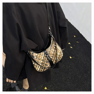 Detail of woven hobo bag with adjustable leather strap and textured weave pattern