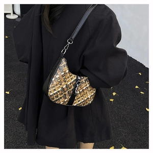 Detail of a retro tricolor woven half-moon bag with black leather strap on a model