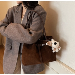 Dettaglio della borsa tote in pelle opaca marrone scuro con ciondolo a forma di cane