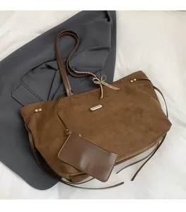 Detail der Wildleder-Shopper mit Metalllogo, Nieten und karierter Schleife