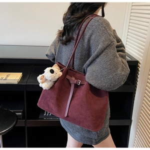 Dettaglio borsa tote bordeaux in pelle scamosciata con cinturino e charm orsetto bianco