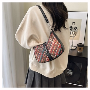 Detail of multi-color woven shoulder bag with black leather strap and silver metal buckle