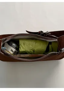 Top view of open dark brown suede baguette bag showing spacious interior capacity