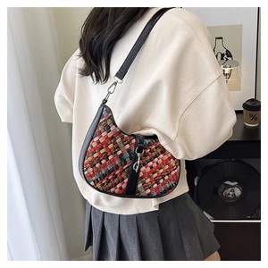 Detail of retro multi-color woven shoulder bag with black leather strap and metal clasp