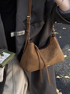 Brown suede crescent underarm bag with tassels and adjustable strap for autumn style