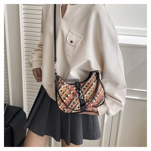 Detail of hobo bag with vibrant woven patterns and adjustable black leather strap