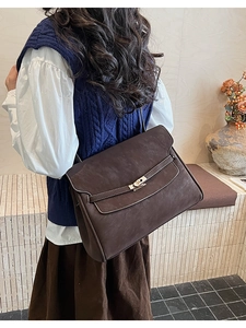 Detail of vintage coffee shoulder bag with gold twist lock and matte leather texture