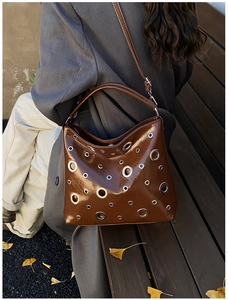 Sac à main en cuir verni marron avec détails d'œillets argentés et bandoulière chic