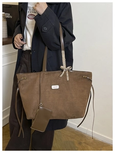 Detail der braunen Wildleder-Tragetasche mit kleiner Schleife und Mode-Plakette