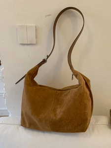 Minimalist caramel suede hobo bag with vintage shoulder strap and silver buckle
