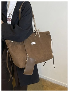 Brown faux suede tote bag with fashion tag and checkered bow detail close-up